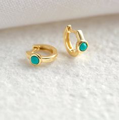 "These beautiful little huggie hoops with a central bezel-set turquoise stone are the perfect mix of subtle and statement. A versatile and elegant pair that looks beautiful layered with other small earrings, but is also perfect worn alone for a more minimal look. * D E T A I L S * ∙ Sold as a PAIR ∙ Material: .925 Sterling Silver or 18K Gold Plated over .925 Sterling Silver ∙ Stone: Reconstituted Turquoise ∙ Dimensions: Hoop diameter: 11mm // Turquoise: 3mm ∙ Hypoallergenic & nickel-free * P Tiny Gold Hoop Earrings, Small Gold Hoop Earrings, Minimalist Earrings Gold, Geometric Hoop Earrings, Turquoise Hoop Earrings, Turquoise Hoops, Bezel Earrings, Tiny Stud Earrings, Gold Filled Earrings