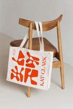 an orange and white bag sitting on top of a wooden chair