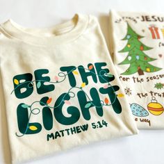 Spread the light of Christmas with this festive kid-sized unisex shirt. Featuring a stylish Christian design, it's the perfect way for your little one to celebrate the season with family and friends. Get ready to spark joy and be the light! The front of this shirt says “Be The Light”. The back is blank. The Joy Of Christmas Is Family, Cricut Throw Pillows, School Christmas Shirt, Christian School Shirt Designs, Popular Christmas Shirts, Sublimation Shirts Christmas, Christmas Shirts Boys, Cute Christmas T Shirts, Christmas Christian Tshirts