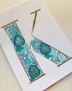 a card with some gold foil on top of it and blue paper in the middle