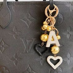 a black purse with gold and white charms hanging from it