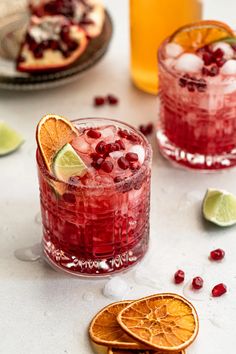 pomegranate cocktail with orange slices and limes