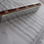 a harmonica resting on top of sheet music