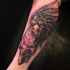 a woman's leg with a tattoo on it that has a native american headdress