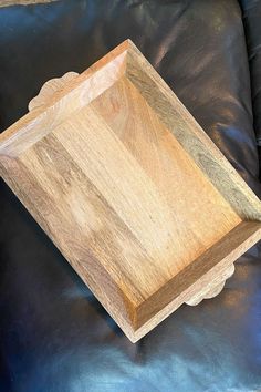 a wooden tray sitting on top of a black leather couch