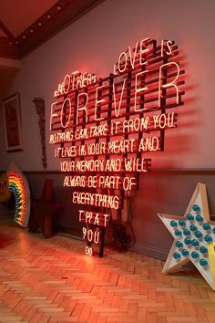 a neon sign that says love is forever on the wall next to a wooden floor