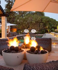 an outdoor fire pit with two large white bowls on it