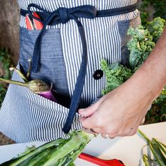 a person wearing an apron with vegetables in it