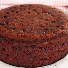 a chocolate cake sitting on top of a white plate next to a red and white checkered napkin