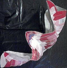 a pair of red and white shoes sitting on top of a black leather couch next to a plastic bag