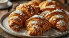 croissants with powdered sugar are on a plate