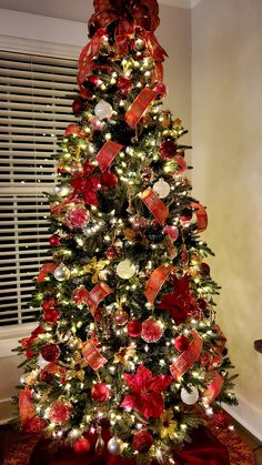 a decorated christmas tree with red and gold ornaments