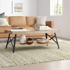 a living room with a couch, coffee table and rugs in front of it