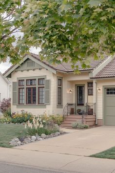 a house that is in the middle of some grass and flowers on the front lawn