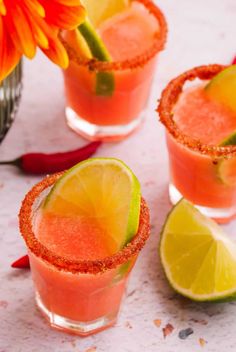 three glasses filled with watermelon margaritas and garnished with lime slices