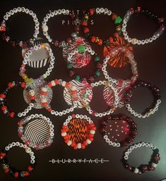 a bunch of bracelets that are sitting on top of a black table with beads