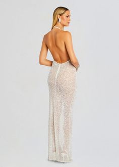 the back of a woman wearing a white gown with sequins and an open back