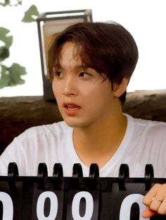 a young man holding up a black and white calendar