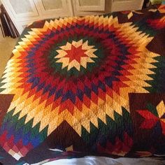 a multicolored quilt on a bed in a room