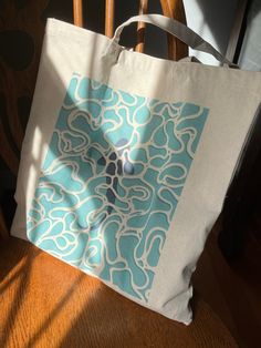 a blue and white bag sitting on top of a wooden chair