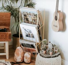 there is a guitar and other items on the floor next to a potted plant