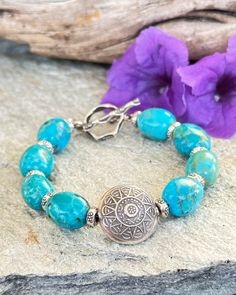 This classic Boho style Turquoise bracelet features amazing Sky blue Turquoise nuggets from the Kingman Mine in AZ. A large round Hilltribe Silver Sun charm is the focal. Each Turquoise nugget is separated by a small fine Silver Hilltribe bead. A Tribal fine silver Toggle is the closure. This Turquoise is so beautiful! Wear alone or stack with your other faves. Spiritual Nickel-free Turquoise Beaded Bracelets, Bohemian Turquoise Beaded Nickel Free Bracelets, Bohemian Turquoise Beaded Bracelets Nickel Free, Bohemian Turquoise Beaded Nickel-free Bracelets, Rustic Turquoise Bracelet Jewelry, Rustic Turquoise Bracelet, Rustic Blue Adjustable Bracelets, Rustic Adjustable Blue Bracelets, Rustic Turquoise Bracelets For Jewelry Making