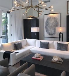 a living room filled with white couches and lamps