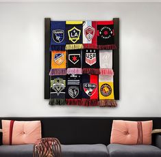 a living room filled with furniture and lots of colorful blankets hanging on the wall above it