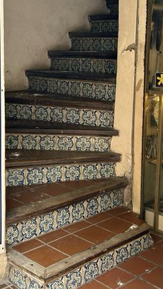 an old set of stairs with blue and white tiles