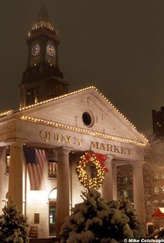 a building with christmas lights on it and a clock tower in the background