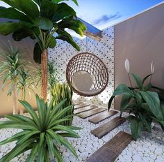 some plants are sitting on the ground in front of a wall with a hanging chair