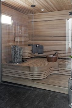 a wooden sauna with glass doors in a bathroom