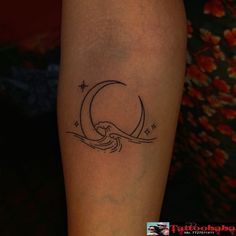 a woman's leg with a tattoo on it that has a crescent moon and stars