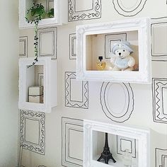 the wall is decorated with black and white frames, including a teddy bear in a niche