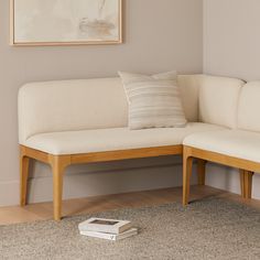 a white couch sitting on top of a hard wood floor next to a book shelf