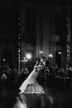 a bride and groom sharing their first dance at the reception in black and white photo