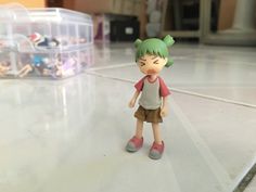 a small toy girl standing on top of a white floor