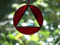 a stained glass ornament hanging from a tree