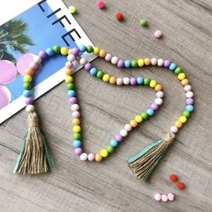 colorful beads and tassels are on the table next to a magazine with balloons