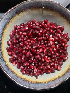 pomegranate in a bowl sitting on top of a stove burner, ready to be cooked