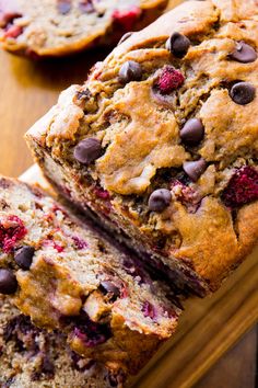 two loafs of banana bread with raspberries and chocolate chips on the side