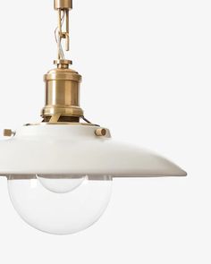 a white and gold colored light fixture with an oval glass shade hanging from the ceiling