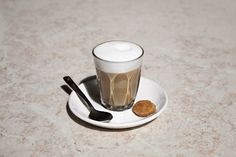 a cup of coffee and spoons on a saucer