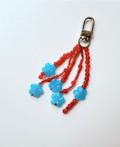 a red and blue beaded keychain with two flowers on it's side