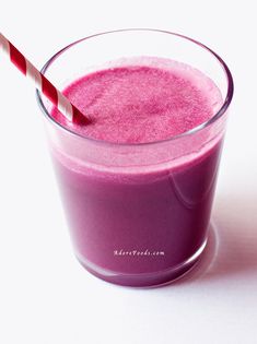 a smoothie in a glass with a red and white striped straw sticking out of it