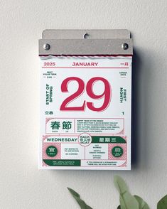 a calendar hanging on the wall next to a plant