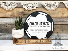 a personalized soccer ornament on a shelf next to a potted plant