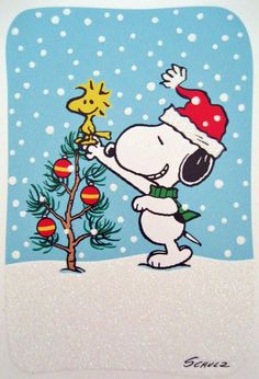 a snoopy christmas card with a cartoon character holding a star on top of a tree