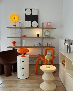 a living room filled with furniture next to a wall mounted shelf covered in art pieces