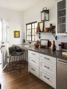 a kitchen with white cabinets and wooden floors